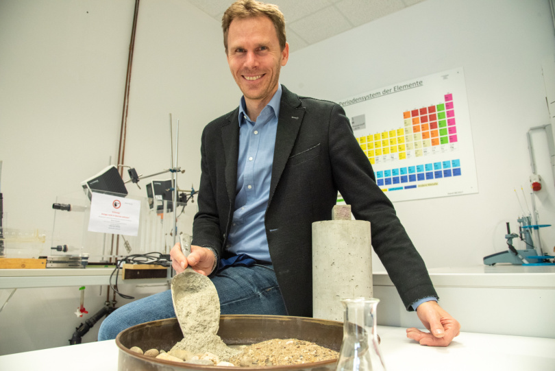 Prof. Dr. Jörg Harnisch zeigt die Bestandteile eines klassischen 3-Stoff-Betons: Zement, Gesteinskörner und Wasser. Foto: Katharina Kipp / FH Münster