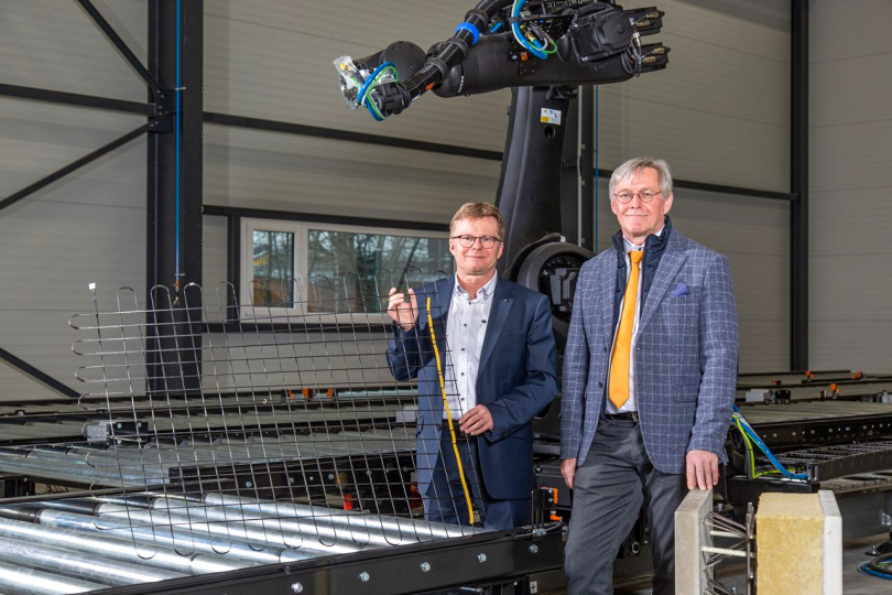 Prof. Tilo Heimbold (links) und Prof. Klaus Holschemacher mit einem Carbonbetongelege mit integriertem AS-Interface-Kabel im Carbonbetontechnikum der HTWK Leipzig (Foto: Maximilian Johnson/HTWK Leipzig) 