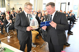 Staatsminister Christian Bernreiter übergibt ein kleines Abschiedsgeschenk an Amtschef Helmut Schütz - Foto: StMB