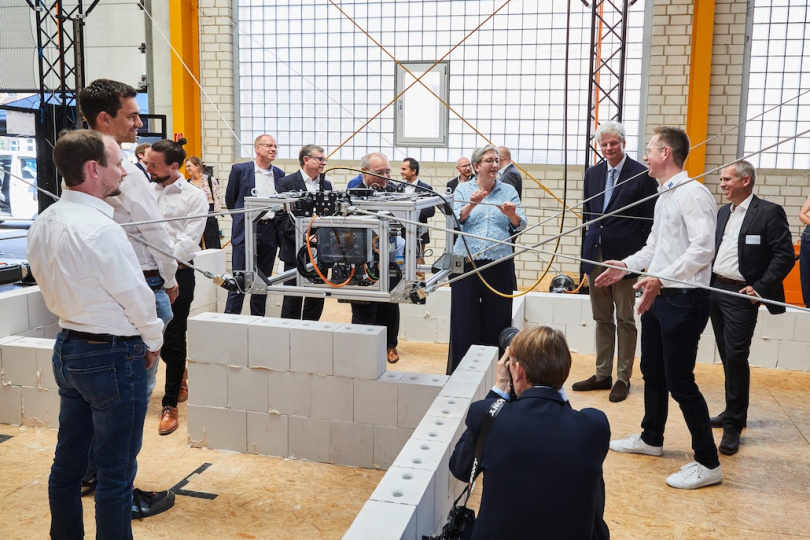 Bundesbauministerin Klara Geywitz lobt Entwicklung der Seilroboter-Technologie für den Mauerwerksbau