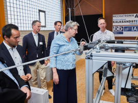 Bundesbauministerin Geywitz zeigte großes Interesse für die technischen Details des Seilroboters. Foto: Henning Stauch – Bundesverband Kalksandsteinindustrie e.V.