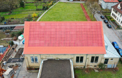 Ziegelrote PV-Anlage direkt in Dach eines historischen Gebäudes integriert