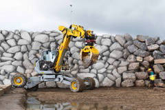 Autonomer Bagger baut sechs Meter hohe Trockensteinmauer