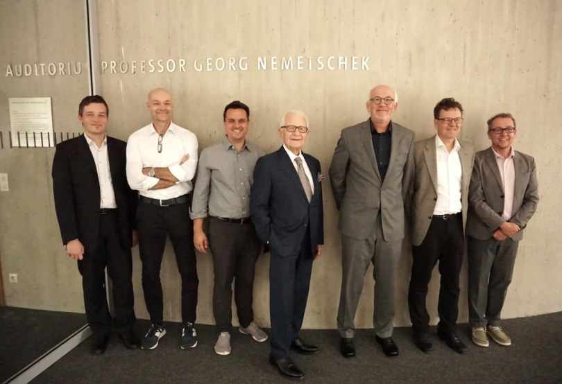 Prof. Georg Nemetschek im gleichnamigen Auditorium der HM (Mitte) gemeinsam mit Dr. Josef Böck, Stiftungsvorstand der Nemetschek Innovationsstiftung, umringt vom Kernteam des AInspect2Twin Projektteams von den HM-Fakultäten für Bauingenieurwesen und Geoinformation - v.l.n.r: Ludwig Hoegner, Christian Schuler, Cornelius Preidel, Georg Nemetschek, Josef Böck, André Dürr und Christoph Dauberschmidt (Foto: HM) 