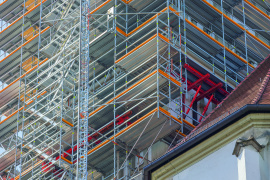 Kombinierbare Baukastensysteme: Oberhalb der dreiseitig umschließenden Dachkonstruktion der Basilika bildeten Variokit Konsolbühnen die sichere Basis für das darüber angeordnete Turmgerüst. (Foto: PERI Deutschland)