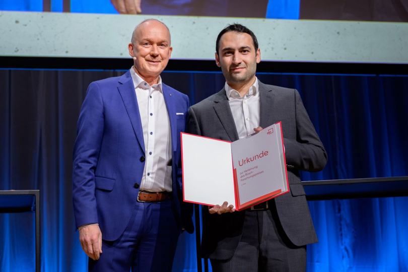 Preisverleihung des Rüsch-Forschungspreises 2025 durch den DBV-Vorsitzenden Dr. Matthias Jacob (links) an Dr. Homam Spartali beim Deutschen Bautechnik-Tag. Foto: Heidi Scherm / DBV 