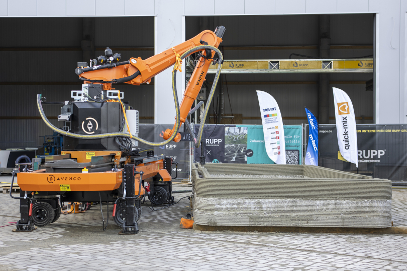 Das gedruckte Modulhaus „Pluto“ wächst durch das 7-Achs-Drucksystem und den beteiligten Projektpartnern von Rupp Gebäudedruck, Avenco, KUKA, m-tec und Sievert. Foto: Rupp Gebäudedruck GmbH.